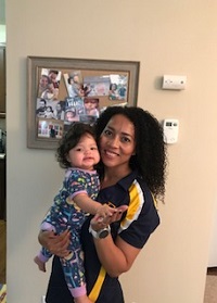 woman with curly hair holding her daughter